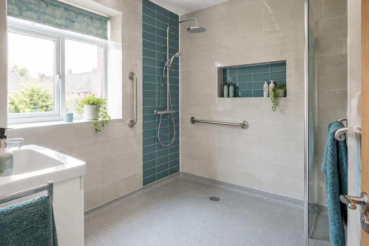 A level-access wet room with a walk-in shower and grab rails